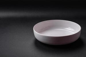 White empty soup bowl on a dark concrete background photo