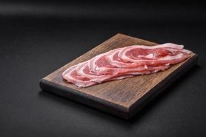 Fresh raw bacon sliced with spices and herbs photo