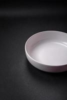 White empty soup bowl on a dark concrete background photo