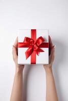 Gift box with ribbon bow in female hands. photo