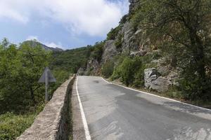 un pavimentado la carretera a lo largo rocoso montañas con un peligroso curva. paisaje. foto