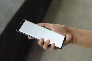 Woman holding smartphone with white screen blank, Copy space photo