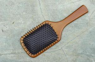 Bamboo Paddle Hair Brush isolated on cement Background photo