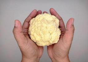 cauliflower is above both hands photo