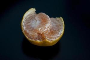 mandarín naranja y pelado segmentos aislado en negro antecedentes. foto