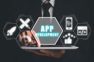 App development concept, Person hand using tablet with app development icon on virtual screen background, Designing application for mobile phone. photo