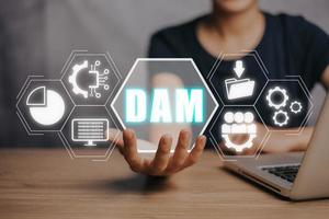 DAM, Digital Asset Management Organization Concept, Person hand holding Digital Asset Management icon on virtual screen. photo