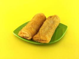 Fried Chinese Traditional Spring rolls food in leaf plate beautiful shape on yellow background photo