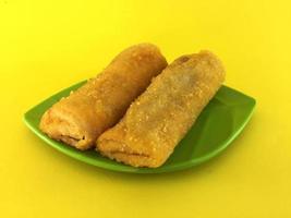 Fried Chinese Traditional Spring rolls food in leaf plate beautiful shape on yellow background photo