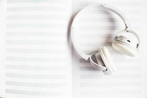 white headphones on a notebook for notes on a white background photo