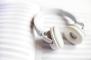 white headphones on a notebook for notes on a white background photo