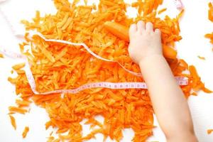 chopped carrots on a white background. child takes a carrot. photo