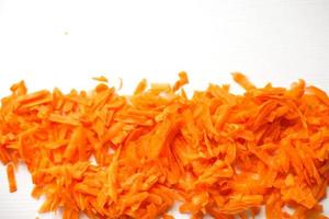 chopped carrots on a white background. raw carrots background photo