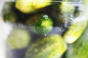 glass jar with a pickled cucumbers. gherkins cucumbers background. photo