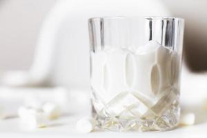 marshmallow in a glass of milk. marshmallows on a white background photo