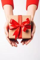 Gift box with ribbon bow in female hands. photo