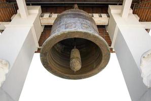 Old church bell isolated on white in the temple of lamphun, thailand photo