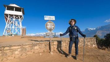 A young traveller trekking in Poon Hill view point in Ghorepani, Nepal photo