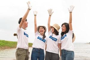 voluntarios desde el asiático juventud comunidad utilizando basura pantalones limpieza arriba naturaleza par foto