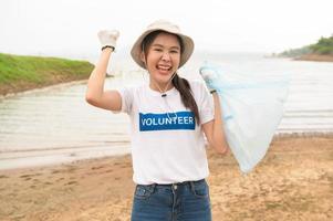 voluntarios desde el asiático juventud comunidad utilizando basura pantalones limpieza arriba naturaleza par foto