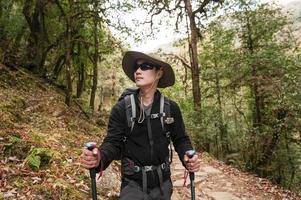 A young traveller trekking on forest trail , Nepal photo