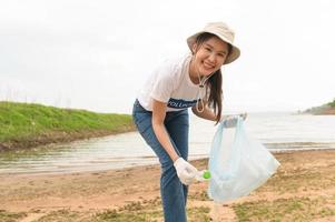 voluntarios desde el asiático juventud comunidad utilizando basura pantalones limpieza arriba naturaleza par foto