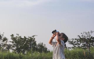 Cute girl looking through binoculars, concept of hiking, camping and adventure. photo