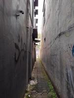 very narrow alley with walls of houses on both sides and with paving blocks path photo