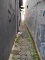 very narrow alley with walls of houses on both sides and with paving blocks path photo