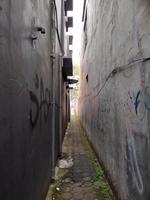 very narrow alley with walls of houses on both sides and with paving blocks path photo