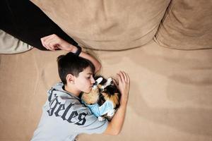 Teenager boy with sleep cat in a bandage after surgery. Care of a pet after cavitary operation sterilization. photo