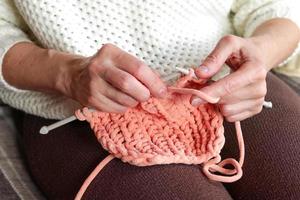de cerca de De las mujeres manos tejido de punto un de lana artículo. hecho a mano ropa. foto