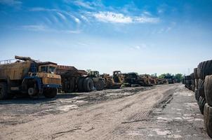 remains of old quarry trucks and machinery on junk yard at sunny day photo