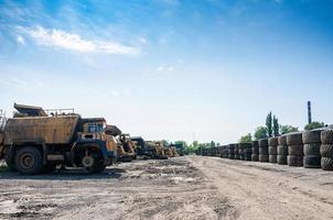 stack of an old quarry truck tires on industrial waste ground at sunny day photo