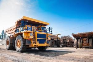 Quarry yellow dump truck drives alone industrial area at sunny day photo