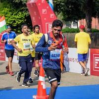 nuevo Delhi, India - marzo dieciséis 2023 - vedanta Delhi medio maratón carrera después codicioso en cuales maratón Participantes acerca de a cruzar el terminar línea, Delhi medio maratón 2022 foto