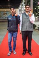 New Delhi, India - March 04 2023 - Unidentified people showing their ink-marked fingers after casting votes in front of polling booth of east Delhi area for MCD local body Elections 2022 photo