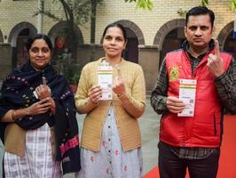 New Delhi, India - March 04 2023 - Unidentified people showing their ink-marked fingers after casting votes in front of polling booth of east Delhi area for MCD local body Elections 2022 photo