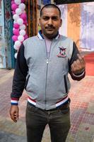 New Delhi, India - March 04 2023 - Unidentified people showing their ink-marked fingers after casting votes in front of polling booth of east Delhi area for MCD local body Elections 2022 photo