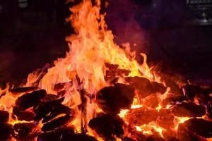 llamas de fuego sobre fondo negro, fondo de textura de llama de fuego blaze, maravillosamente, el fuego está ardiendo, llamas de fuego con madera y hoguera de estiércol de vaca foto