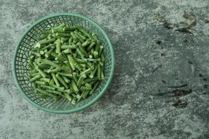 long bean pieces in a green plastic container photo