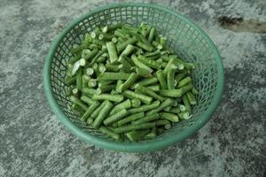 long bean pieces in a green plastic container photo