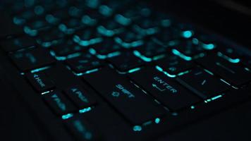 un computadora teclado es un entrada dispositivo ese permite un persona a entrar letras, números, y otro símbolos teclado con verde iluminar desde el fondo foto