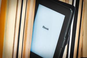 Detail of an e-book reader among classic books photo