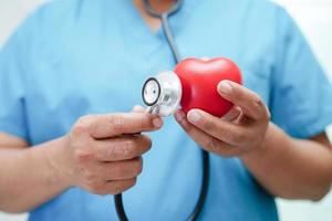 Asian woman doctor holding red heart for health in hospital. photo