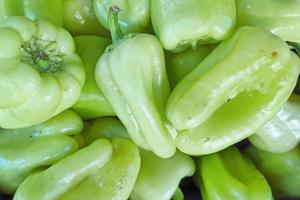 Stack of White sweet pepper on a market stall photo