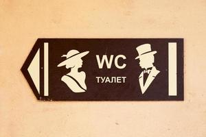 Toilet direction sign in English and Russian photo