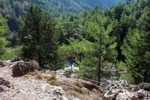 Views in the mountains along the path through the gorge sunny day. View of Gorge, a gorge in the Mountains of Greece, lying on the slopes of Mountains, one of the deepest gorges in the world. photo