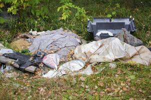 Garbage in the forest. Ecological problem. Plastic, glass, cans. photo