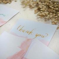 A white card with the word thank you written on it photo